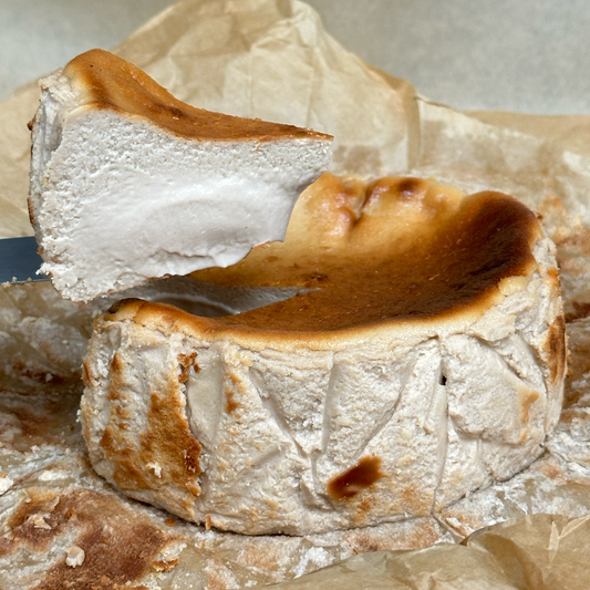 Close-up of a piece of cheese with a browned top on a textured surface