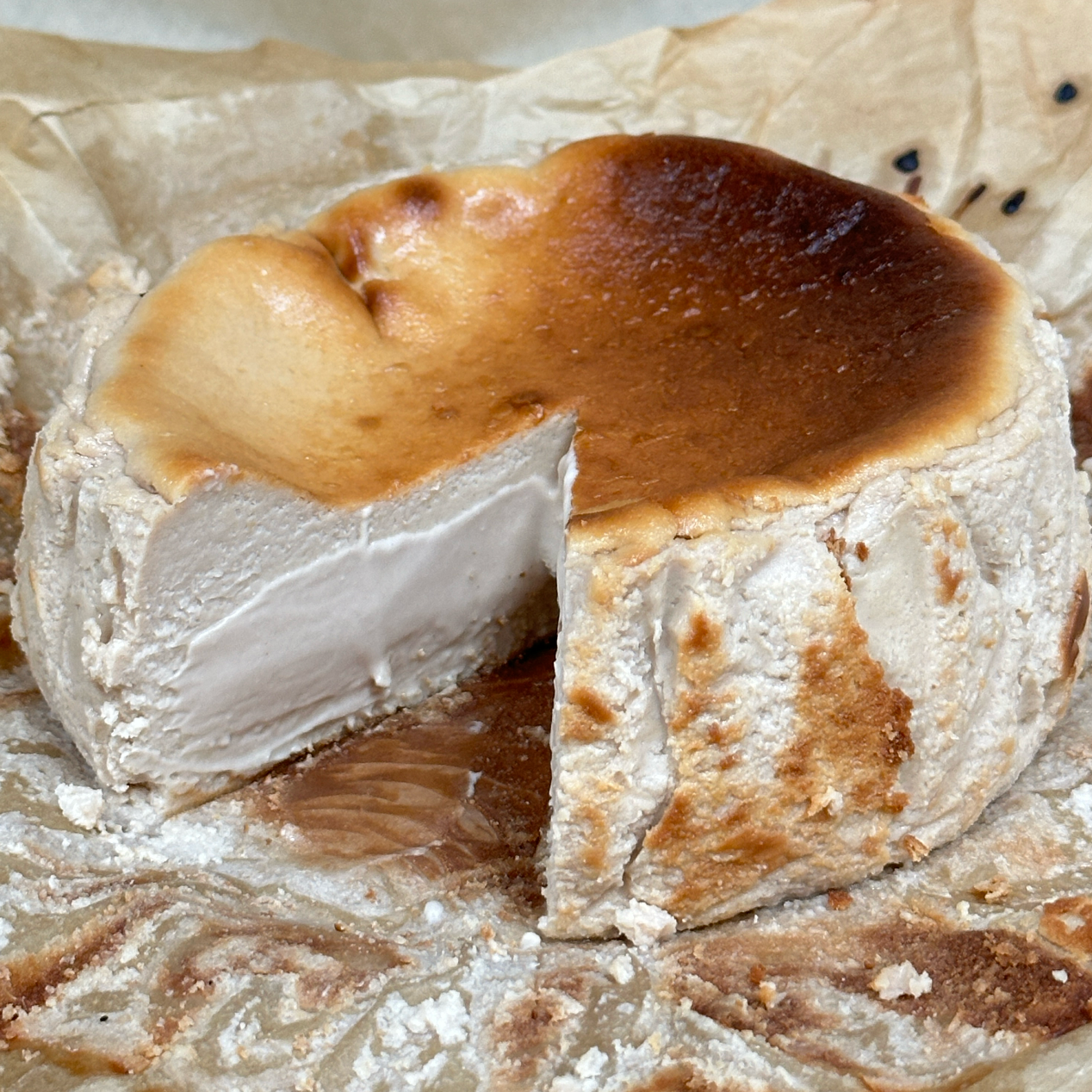 Cheese wheel with a slice cut out on a paper background